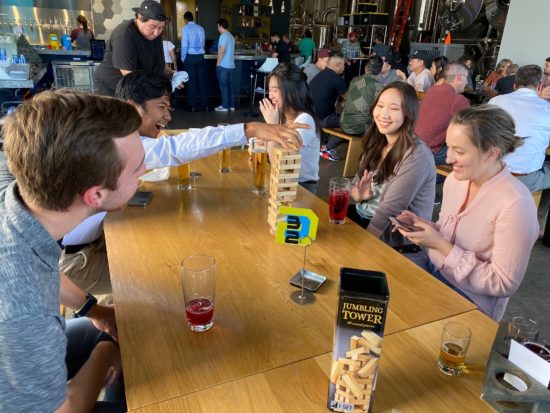KNA employees enjoy a game of Jenga at Happy Hour